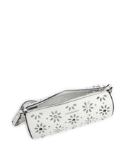 Borsa Izzy Michael Kors in pelle bianca con motivo floreale traforato e borchie, vista dall'alto che mostra l'interno e la zip aperta.