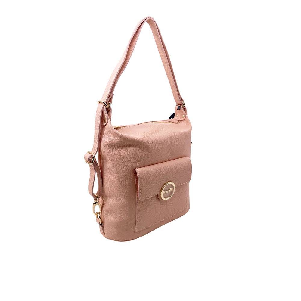 Borsa trasformabile in zaino M*Brc di colore rosa con tasca frontale e dettagli dorati, fotografata di tre quarti su sfondo bianco.