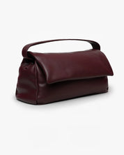 Borsa Puffy Mabash The New Deaux in pelle vegana color bordeaux con manico e chiusura a patta, vista di tre quarti su sfondo bianco.