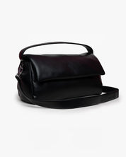 Borsa puffy Mabash nera in pelle vegana modello The Cuti Mega con manico e tracolla staccabile, vista di tre quarti.