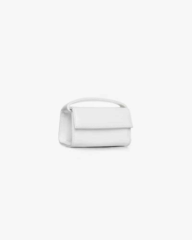 Borsa The Latte Baby OG Mabash bianca con manico superiore. Un'elegante Borsa pelle vegana verniciata fotografata su sfondo bianco.
