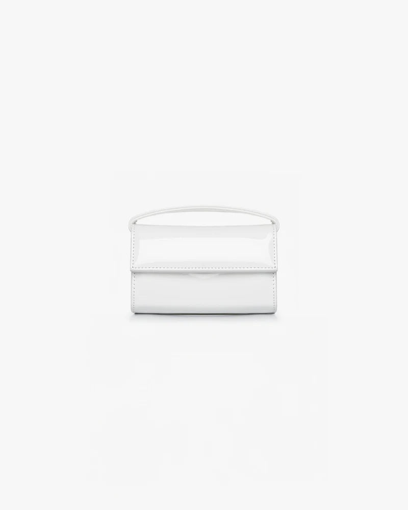Borsa pelle vegana verniciata bianca The Latte Baby OG con manico superiore e chiusura a patta, vista frontale su sfondo bianco.