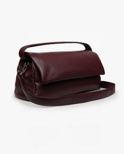 Borsa Puffy Mabash The New Deaux in pelle vegana color bordeaux, dotata di manico e tracolla staccabile, fotografata su sfondo bianco.