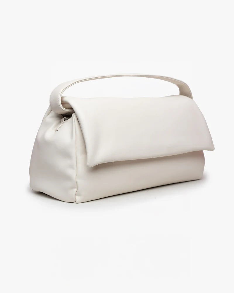 Borsa puffy Mabash The Vanilla in pelle vegana con manico e chiusura a patta, vista di tre quarti su sfondo bianco.
