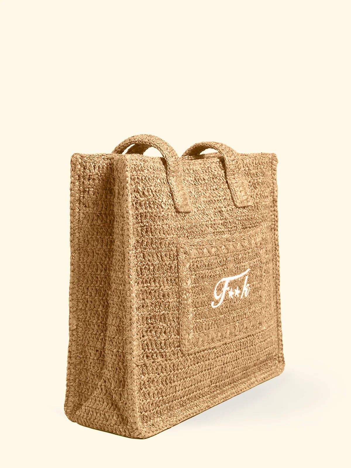 Borsa mare in rafia modello tote bag del brand F**K con logo bianco ricamato e chiusura a bottone, vista di tre quarti.