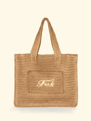Borsa mare in rafia modello Tote Bag del brand F**K con scritta ricamata color panna su fondo neutro.