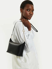 Mini crossbody Furla indossata da una modella con manico a catena in pelle di vitello, elegante e pratica.